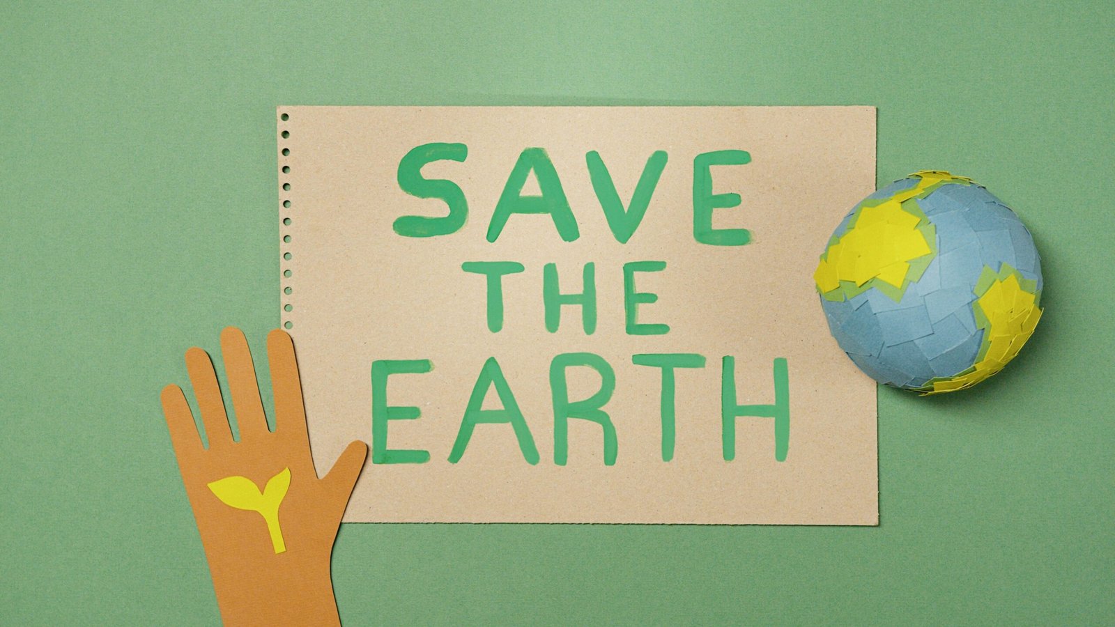 a paper cutout of a hand holding a globe