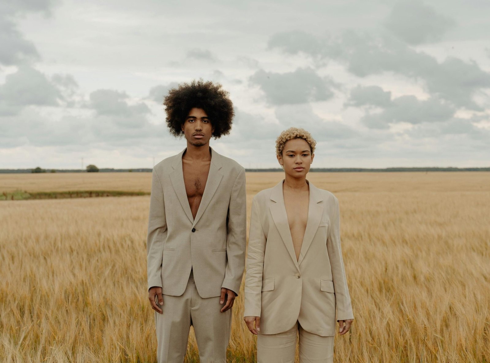 a man and woman standing in a field