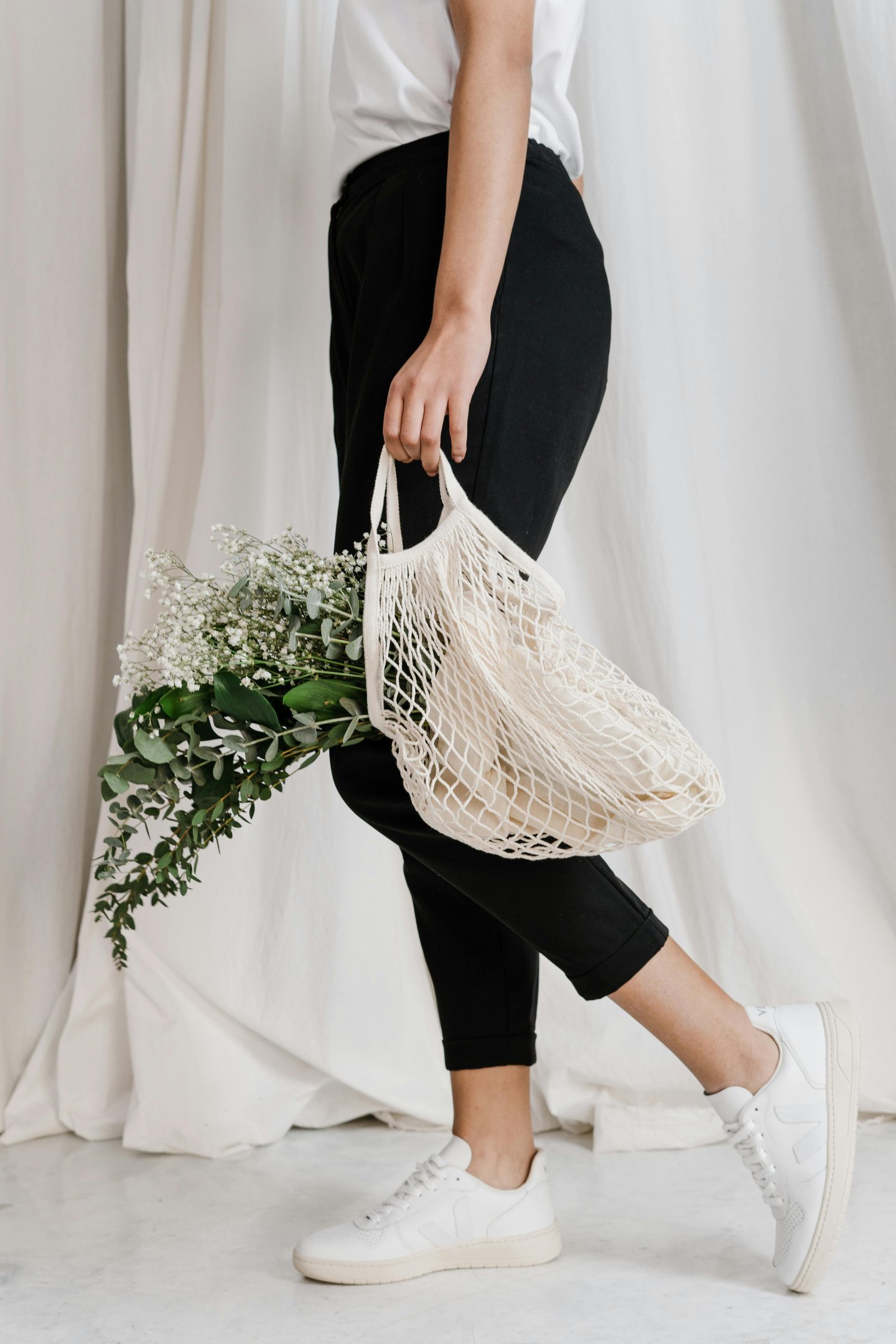 a woman holding a net net baguet bag