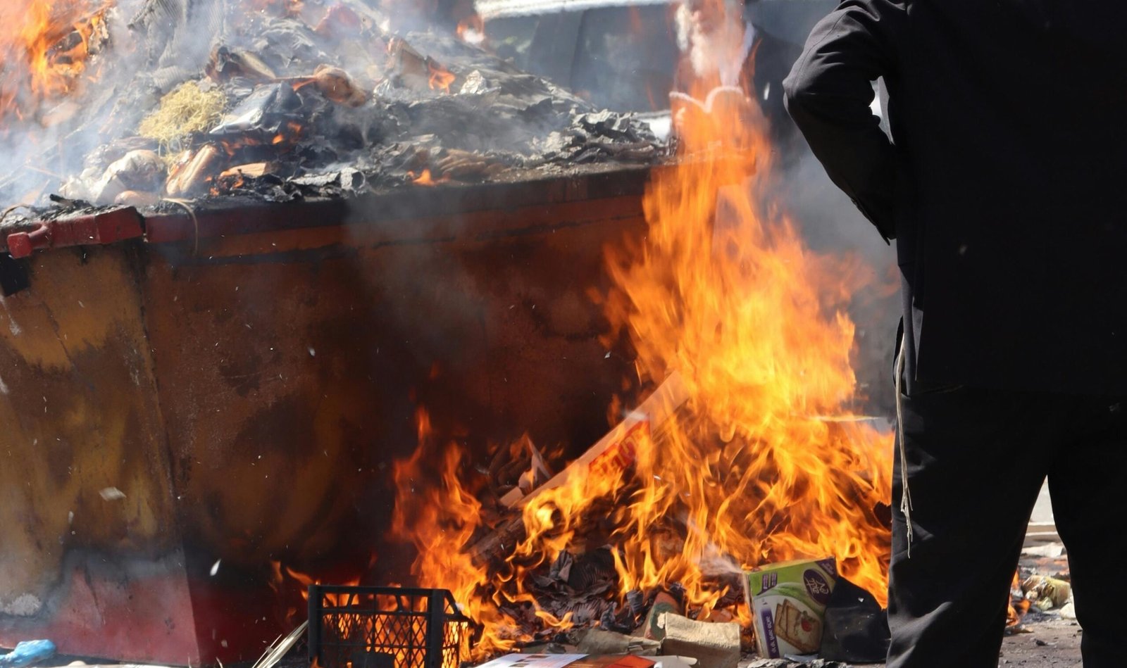 A man standing in front of a burning trash