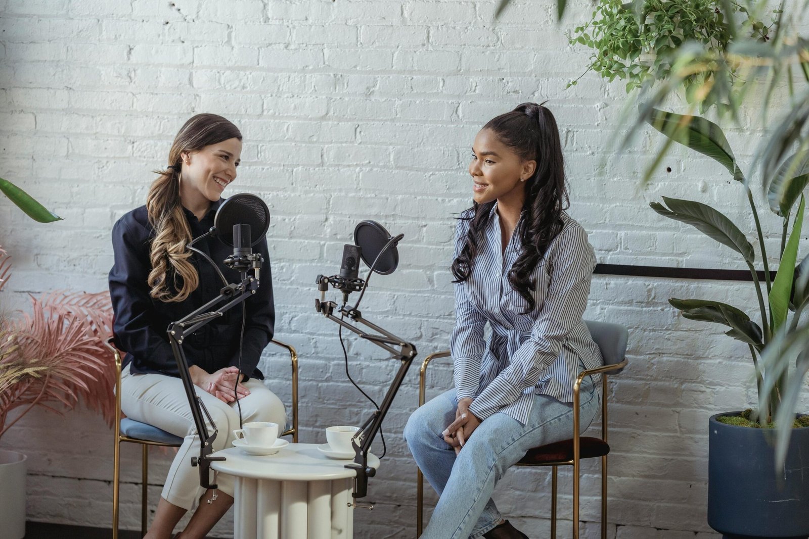 two women sitting in chairs with microphones