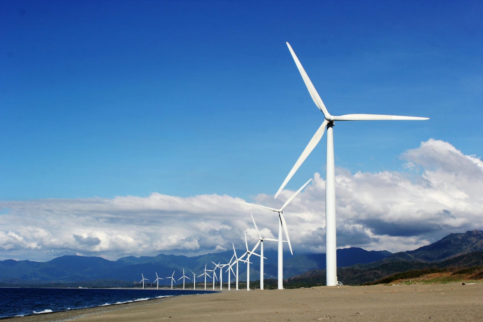 a wind turbine on a beach with a blue sky