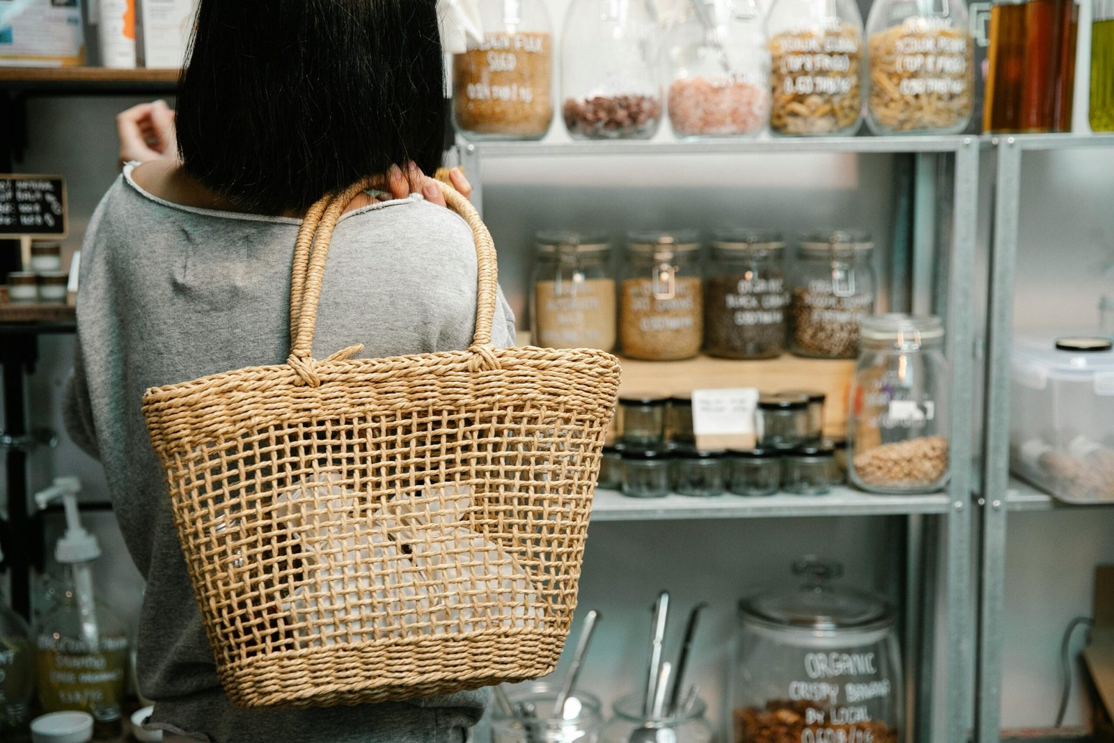 a woman holding a wicker basket bag in a store