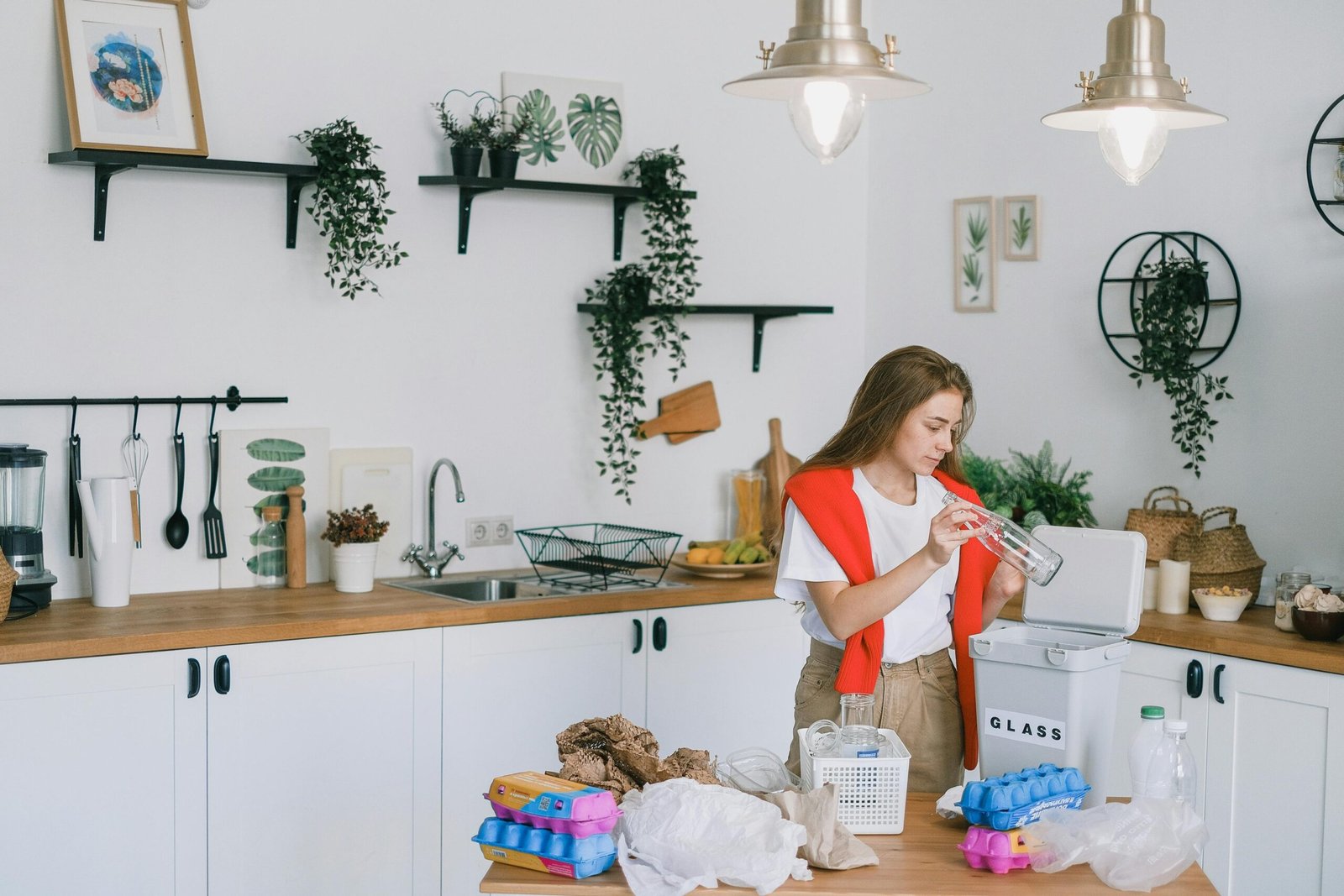 a woman in a red vest and white shirt is standing in a kitchen